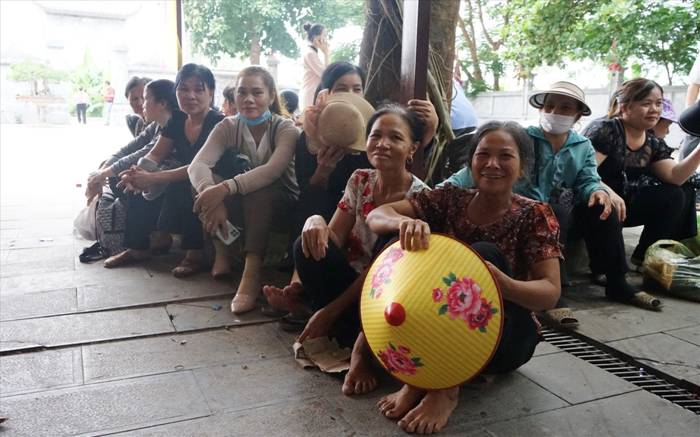 Do quá đông, nên nhiều người phải ngồi chờ bên ngoài sân đền. Ảnh: Quách Du
